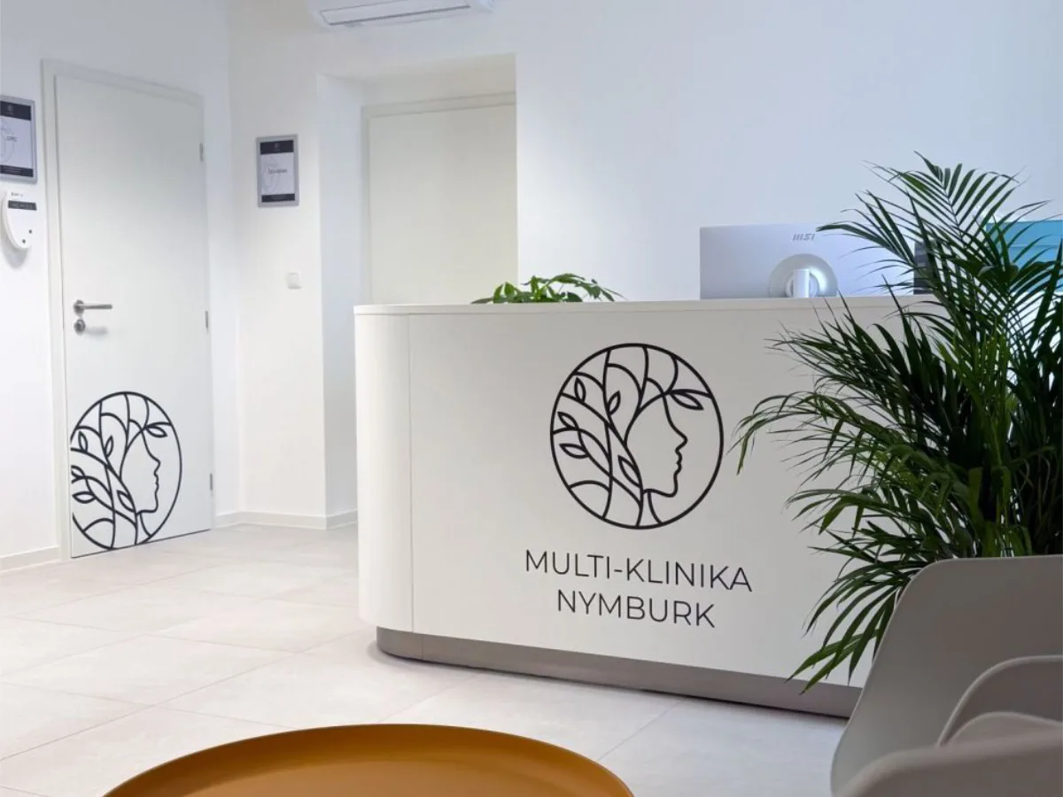 Recepce Multi-kliniky Nymburk s logem na pultu